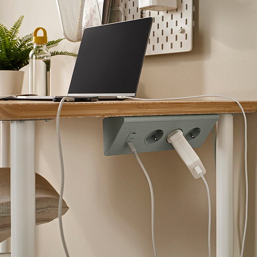 Configuración de escritorio minimalista con computadora portátil y cable SKOTAT, perfectamente organizado.