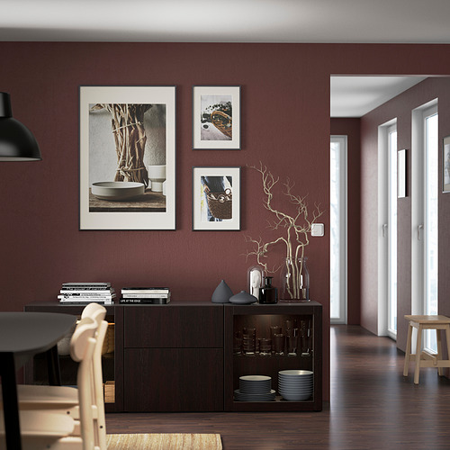 Comedor moderno con pared de color rojo oscuro, mueble negro, mesa de madera, sillas y jarrones decorativos.