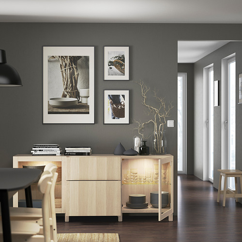 Comedor moderno aparador de madera con estantes ajustables, platos, vasos y elementos decorativos. El arte de la pared y las paredes grises realzan el diseño elegante.