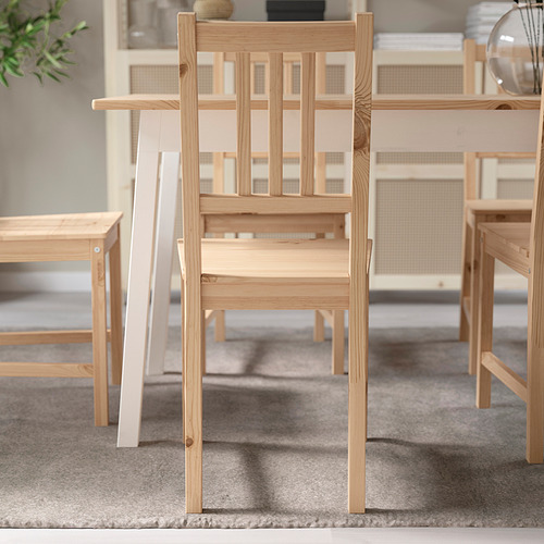 Silla de madera con listones verticales, diseñada para encajar debajo de la mesa, que ofrece una funcionalidad que ahorra espacio.