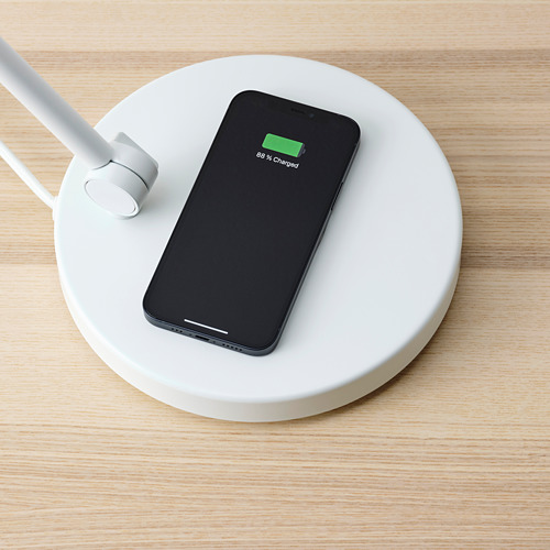 Cargador de teléfono inalámbrico en una lámpara. El smartphone muestra el 88% de carga.