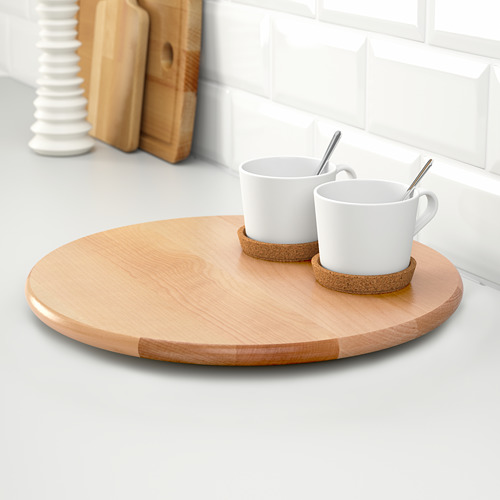 Bandeja redonda de madera con dos tazas blancas y posavasos sobre encimera blanca.