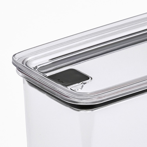 Primer plano de un recipiente de plástico transparente para alimentos con tapa segura con botón.