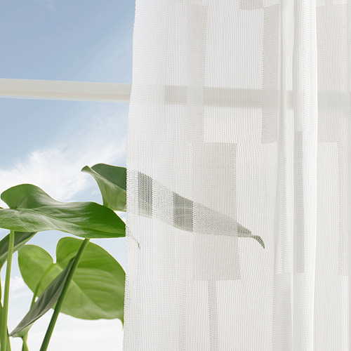 La cortina transparente con diseño de patrón de luz difunde la luz del día, ofreciendo privacidad mientras se conecta a la vista exterior.