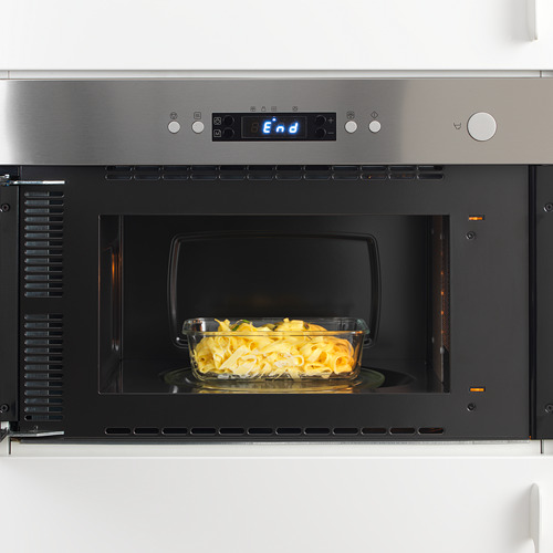 Horno de microondas incorporado con plato de vidrio apto para horno en el interior, la pantalla digital iluminada muestra el final.