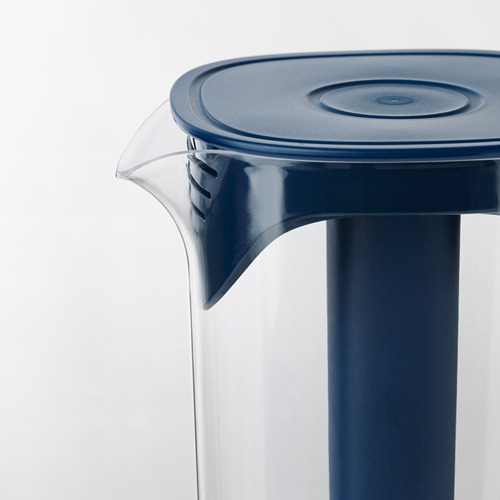La jarra de plástico azul con asa transparente y tapa, diseñada para enfriar bebidas, se mantiene en posición vertical sobre un fondo blanco.