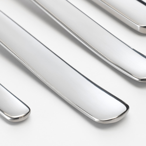 Utensilios de metal pulido cuidadosamente dispuestos. El acabado brillante y el diseño elegante indican alta calidad.