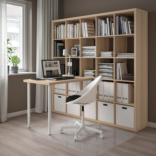 Oficina en casa con escritorio LINNMON, silla, computadora portátil, lámpara y una gran estantería con libros y cajas.