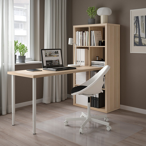 Moderna oficina en casa con estanterías beige KALLAX, escritorio de madera, computadora portátil, silla blanca y vegetación.