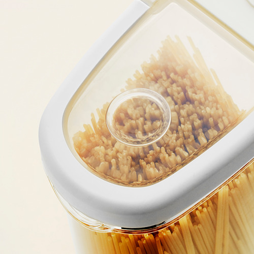 Recipiente de plástico transparente con dos compartimentos llenos de pasta, apilados uno encima del otro.