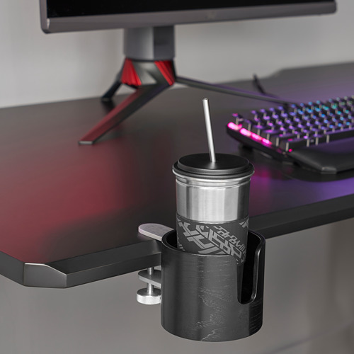 Taza de acero inoxidable en soporte sujeta al escritorio cerca del monitor y el teclado.
