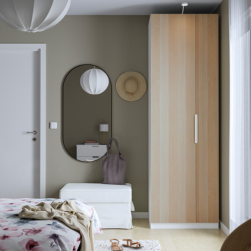 Dormitorio minimalista con armario moderno PAX, ropa de cama floral y una decoración elegante.