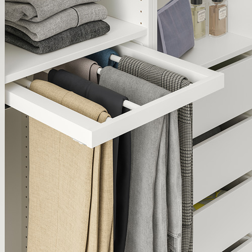 Armario blanco con percha extraíble para pantalones que sujetan pantalones cuidadosamente doblados.