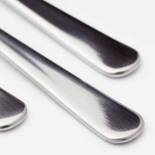 Tres cucharas de acero inoxidable pulido dispuestas cuidadosamente, reflejando la luz, mostrando un diseño elegante y duradero.