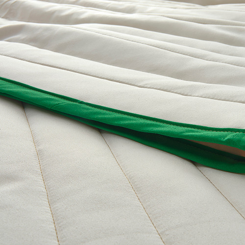 Elegante colcha de tela reciclada en color blanco con ribetes en verde oscuro que luce una textura y un diseño de primera calidad.
