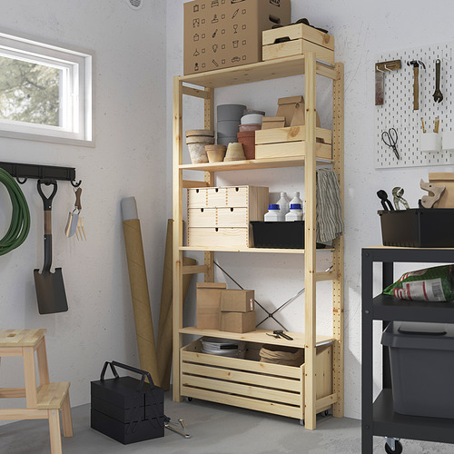 Mueble de almacenamiento IVAR de madera con cajas y herramientas, colocado en el centro, más alto que los objetos circundantes.
