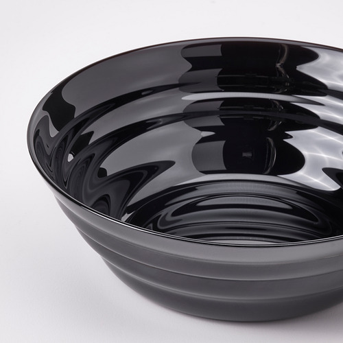 Cuenco negro brillante con patrón de ondas circulares, bordes lisos, superficie reflectante.