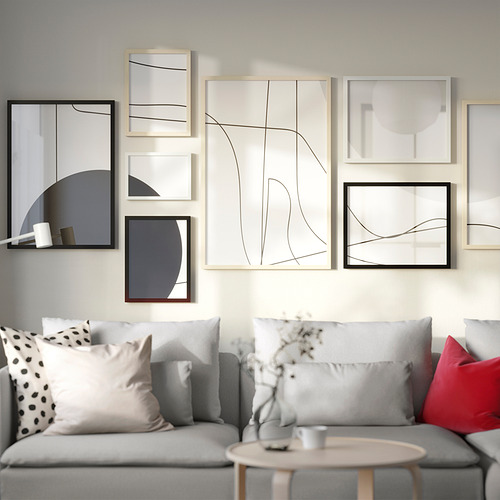 Sala de estar moderna con pared de galería gris, sofá y mesa de centro con flores.