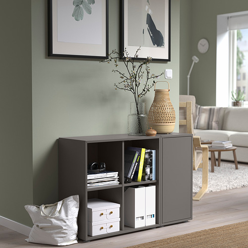 Almacenamiento EKET gris en sala de estar con libros y decoración. Compacto y elegante.