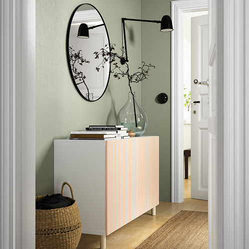 Sala de estar moderna con aparador MEJARP, espejo, lámparas y canasta de ropa contra pared verde.