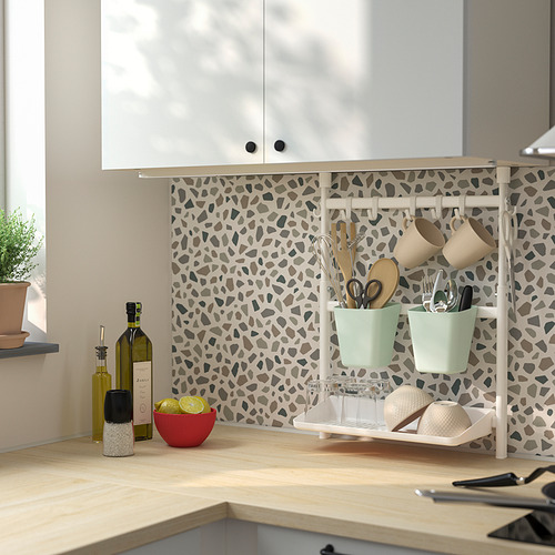 Cocina moderna con encimeras de madera, armarios blancos y estantería SUNNERSTA con utensilios, tazas y un estante para platos.