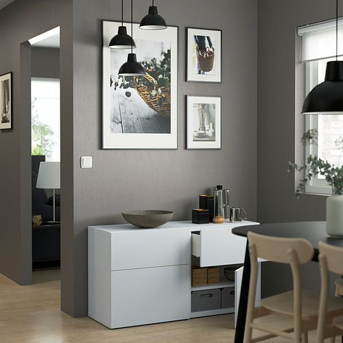 Zona de comedor contemporánea con aparador BESTÅ, lámparas colgantes y sillas de madera.