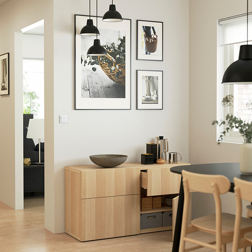 Comedor moderno con aparador de madera, arte y luces. Sala de estar a través de la puerta.
