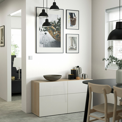 Comedor moderno con aparador BESTÅ, lámparas negras y obras de arte en blanco y negro.