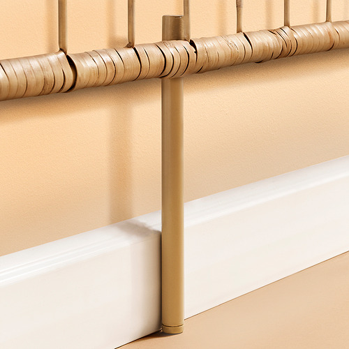 Primer plano de un cabecero de ratán marrón beige con textura detallada tejida a mano, sostenido por un resistente metal de color dorado.