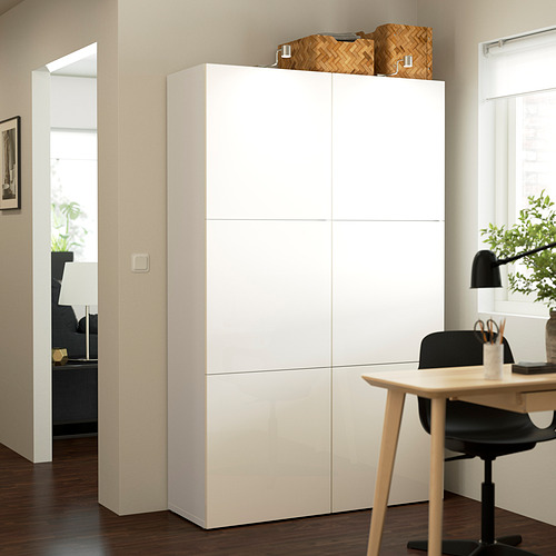 Armario blanco BESTÅ, grande y alto, en una moderna oficina en casa. Almacenamiento alto y elegante con líneas limpias, colocado junto al escritorio.