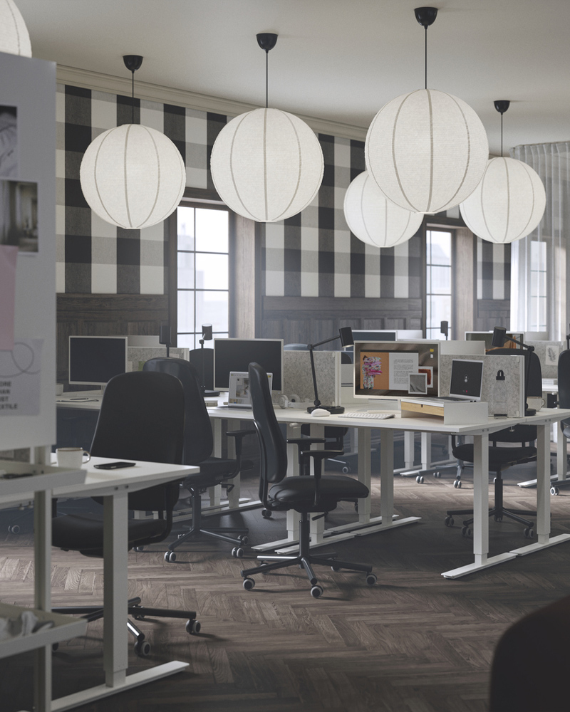 A focus zone in an office with sit/stand desks, SMÖRKULL office chairs, and GULLSUDARE pendant lampshades.