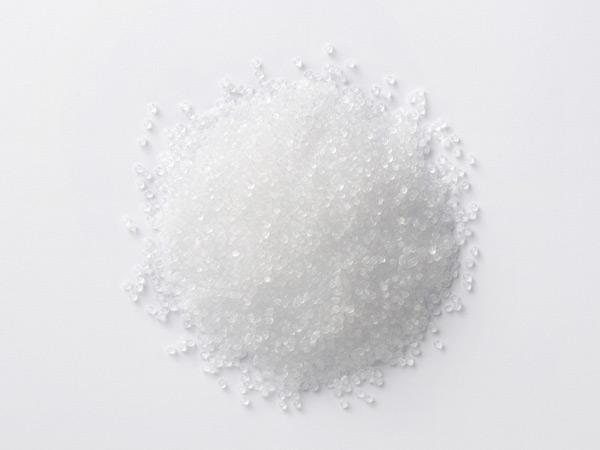 Small heap of translucent plastic pellets on a white background.
