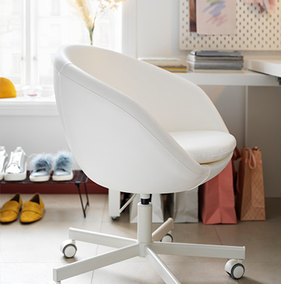 A white office chair with a SKÅDIS pegboard in the upper right corner.