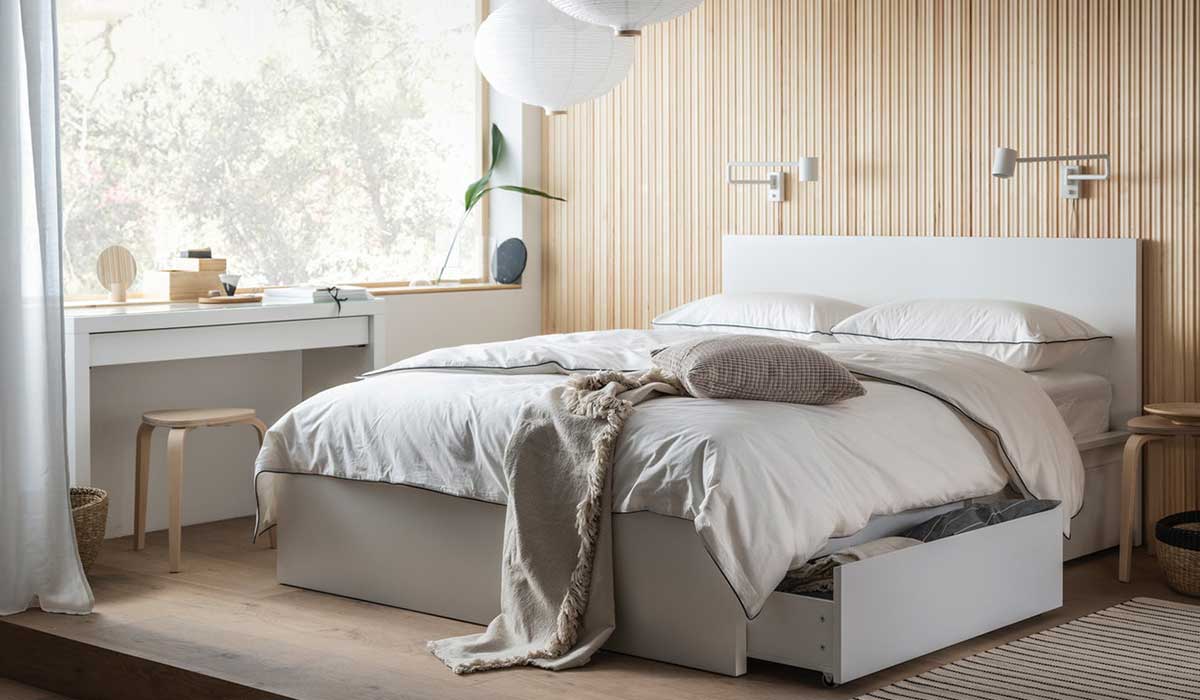 Una cama MALM vestida con una sabana DVALA