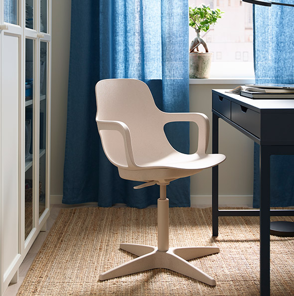 A study with an office chair in the background and a LOHALS rug underneath.