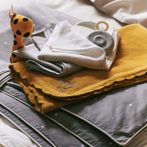 Textiles para bebé sobre una cama.