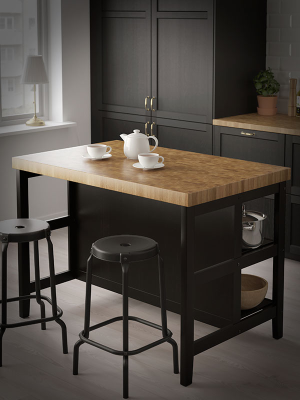 Una isla de cocina VADHOLMA con copas de café VÄRDERA encima.