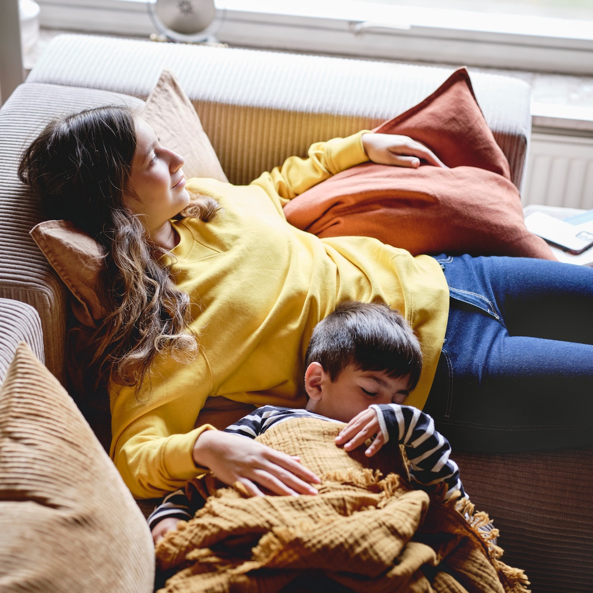 Mother and son resting together on the living room couch.