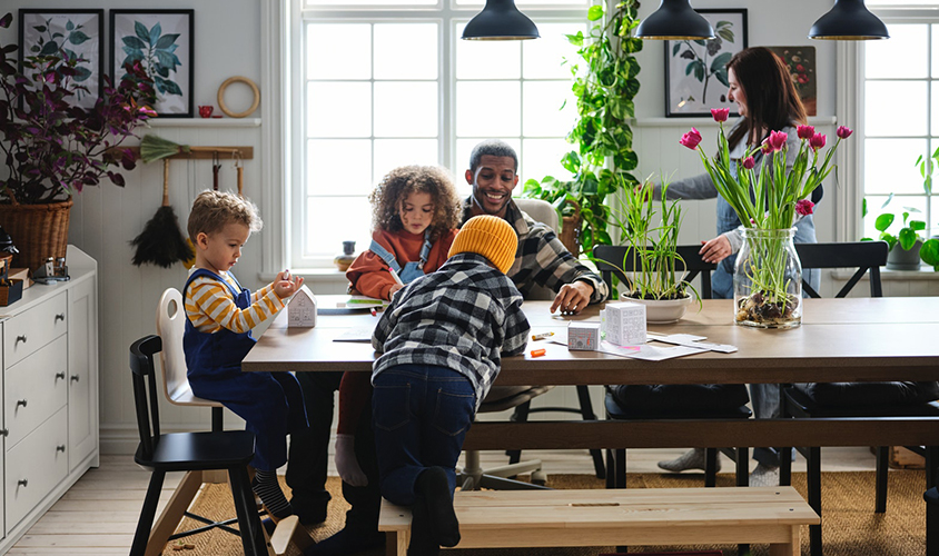 Una familia sentada alrededor de una mesa en una cocina, compartiendo un momento juntos.