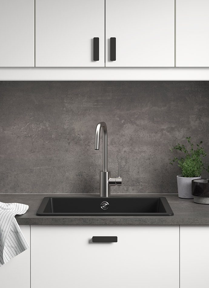 Cocina moderna con gabinetes blancos, fregadero negro, grifo metálico y pared oscura. Minimalista y elegante.