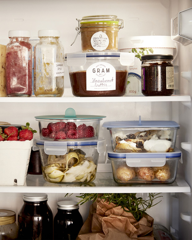 Organized fridge with jars, berries, and leftovers in reusable containers, promoting food preservation and less waste.