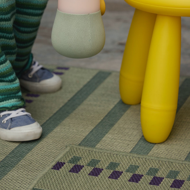 También pueden verse los pies de un niño delante de las patas de un taburete amarillo.