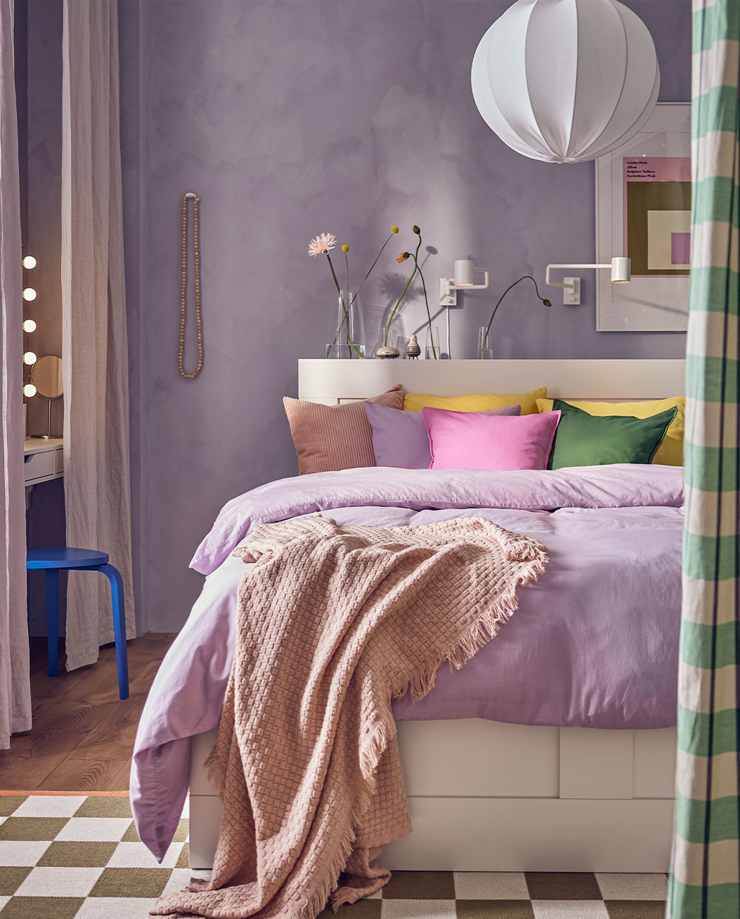 Dormitorio colorido, una cama grande con cojines de colores vivos, una funda de color morado claro 