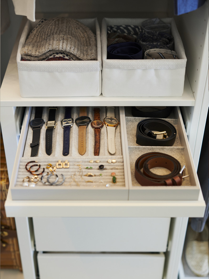 Ropero organizado con cajón de accesorios de tonos claros, creando un ambiente pulcro y funcional.