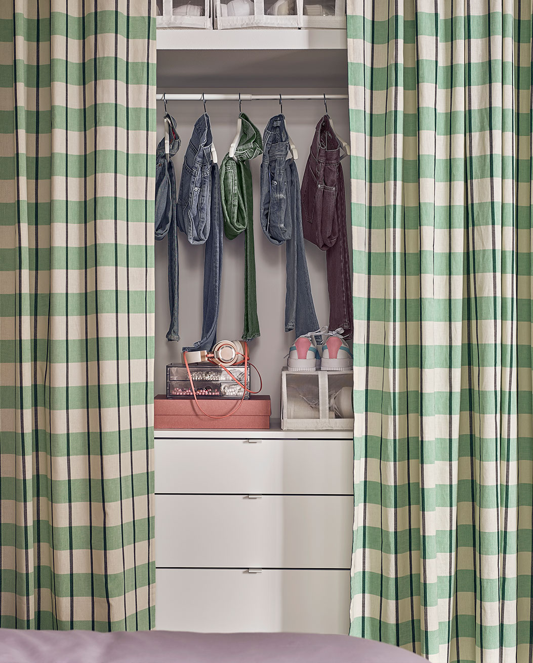 accesorios para organizar la ropa del dormitorio, todo cubierto con una cortina de cuadros verdes.