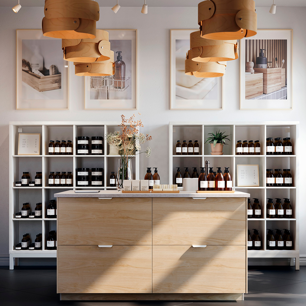 Ambiente de Spa en un estilo moderno elegante sofisticado, al fondo hay un moderno mueble abierto lleno de botellas encima de unas fotos que muestran los servicios que prestan, un gran ventanal, un mostrador tipo isla estilo moderno de madera.