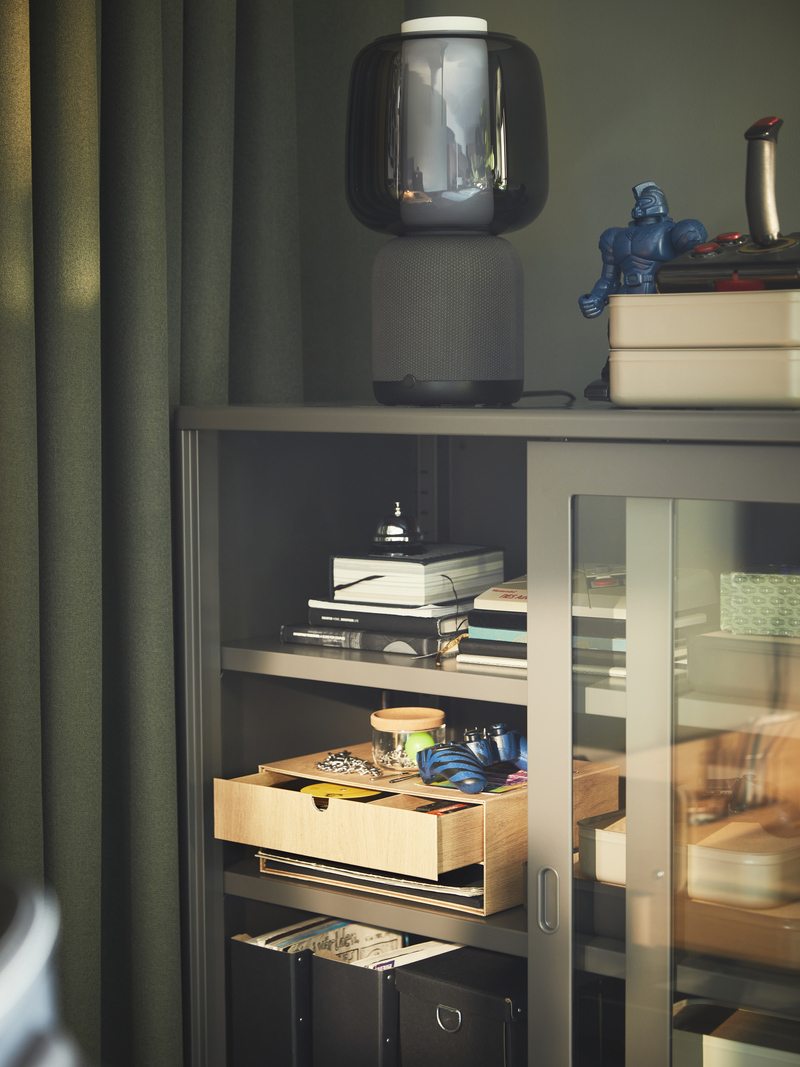 Un gabinete IDÅSEN con puertas deslizables y una lámpara inteligente con Wi-Fi SYMFONISK.