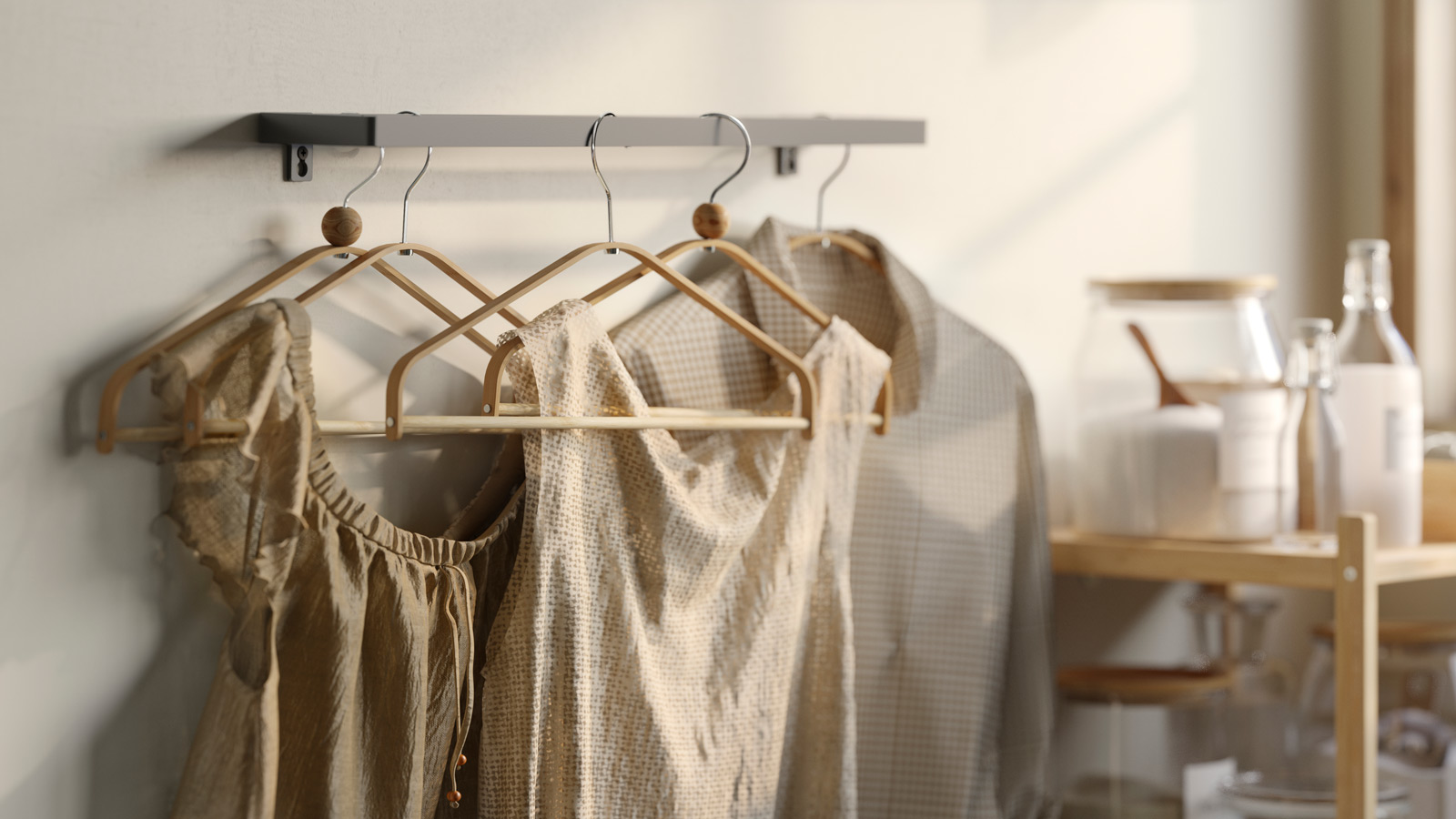 Clothes hooks hung on a towel rail with blouses hung in earth tones.