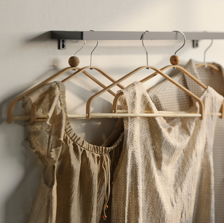 Clothes hooks hung on a towel rail with blouses hung in earth tones.