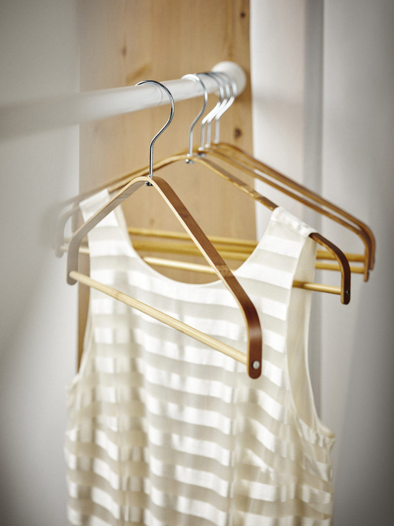 Clothes hooks hung on a bar with a white blouse hanging on it